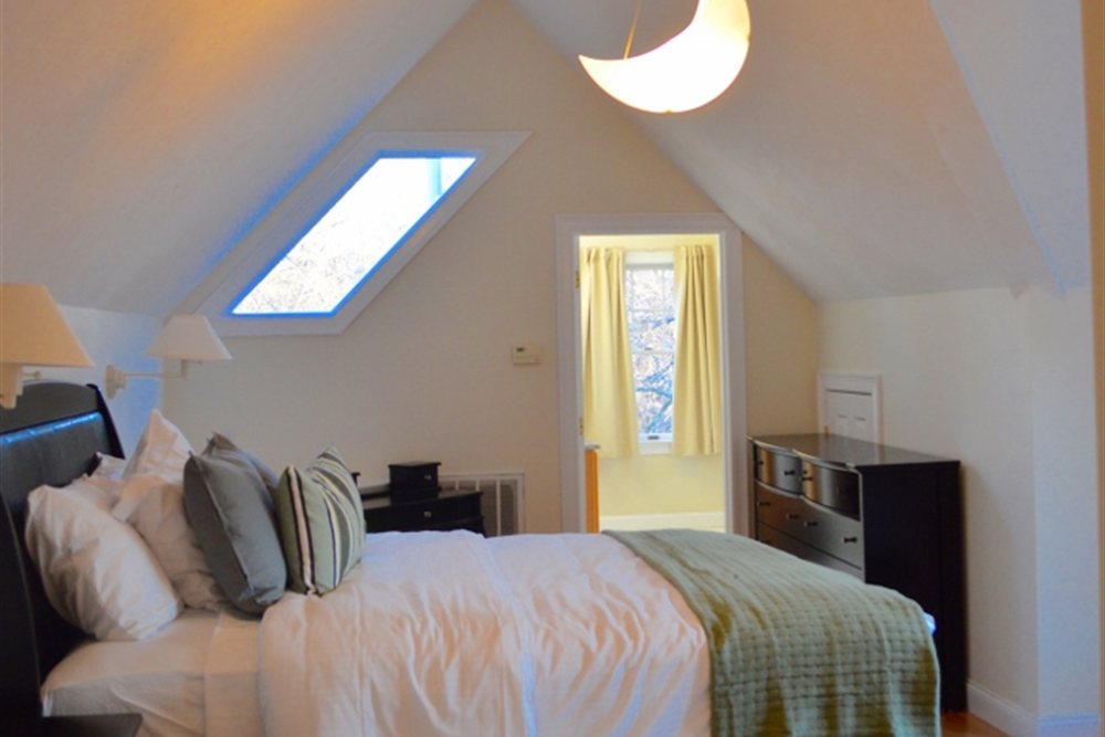 A serene, comfortable bedroom with a vaulted ceiling at Tharros House.